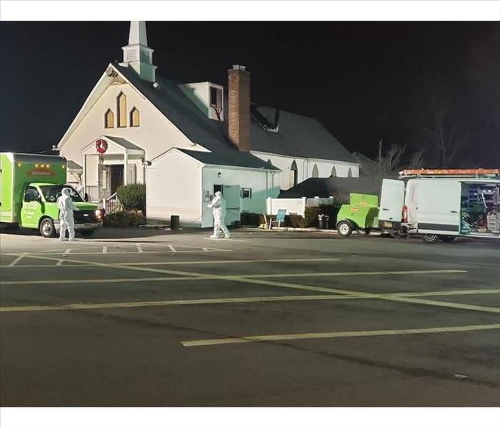 SERVPRO vehicles in front of a church at night