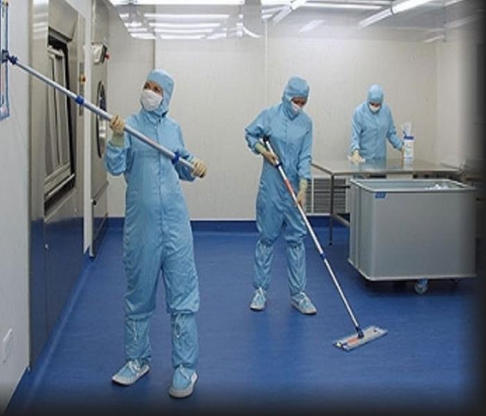 Technicians in Personal Protective Equipment Cleaning in a hospital operating room
